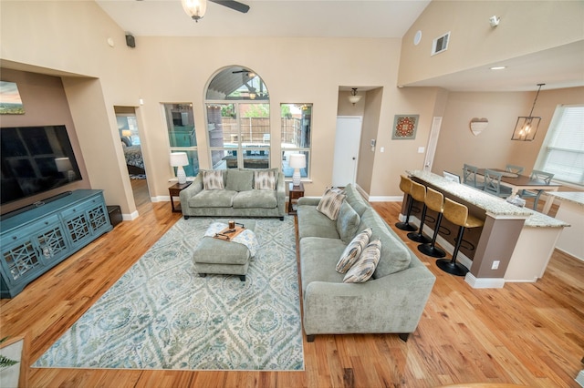 7612 Trevino Dr, Plano, TX 75025 - living area featuring ceiling fan, wood finished floors, baseboards, healthy amount of natural light, and high vaulted ceiling