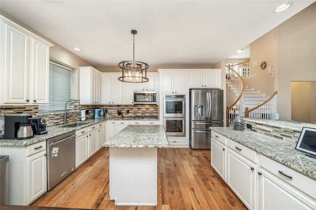 7612 Trevino Dr, Plano, TX 75025 - kitchen with appliances with stainless steel finishes, a sink, backsplash, white cabinetry, and recessed lighting