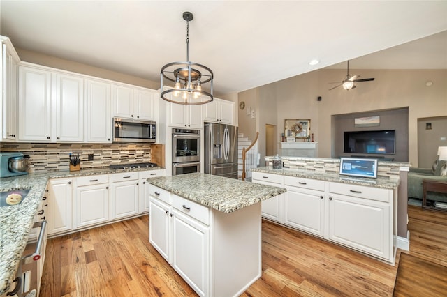 7612 Trevino Dr, Plano, TX 75025 - kitchen with a center island, appliances with stainless steel finishes, decorative backsplash, open floor plan, and a ceiling fan