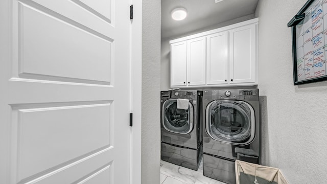 201 Dover Ct, Weatherford, TX 76087 - laundry area with marble finish floor, washing machine and clothes dryer, a textured wall, and cabinet space