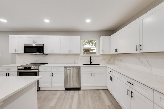 1005 Osborne Ln, Fort Worth, TX 76112 - kitchen featuring white cabinets, tasteful backsplash, appliances with stainless steel finishes, and a sink