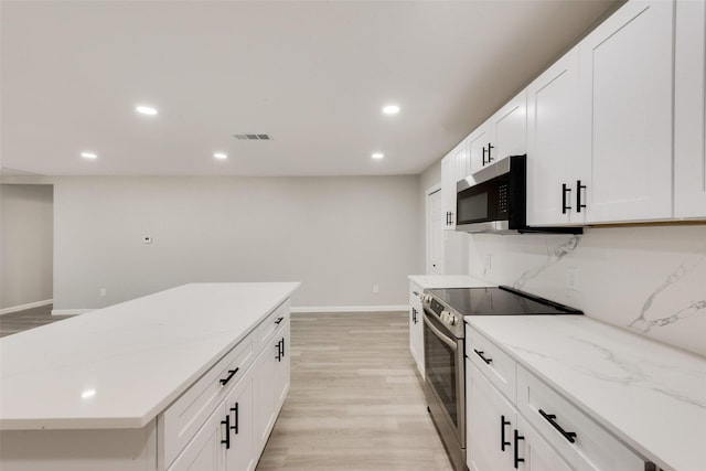 1005 Osborne Ln, Fort Worth, TX 76112 - kitchen featuring light wood-type flooring, stainless steel appliances, baseboards, white cabinetry, and recessed lighting