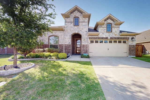 french country inspired facade with concrete driveway, stone siding, a front yard, a garage, and brick siding