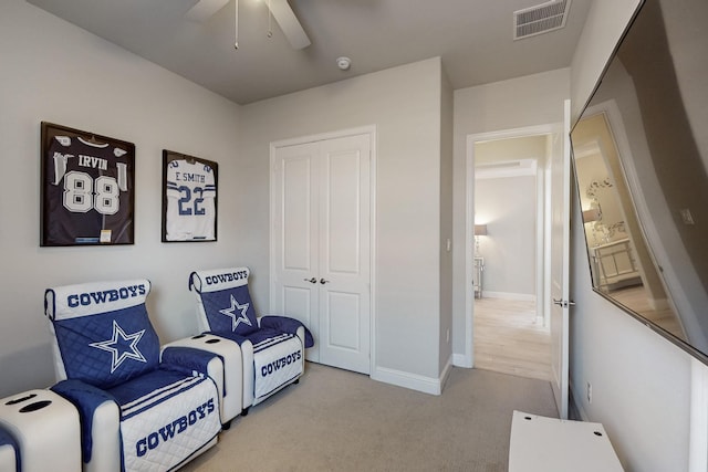 living area with baseboards, visible vents, carpet, and ceiling fan