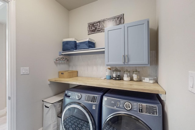 clothes washing area with baseboards, cabinet space, and independent washer and dryer