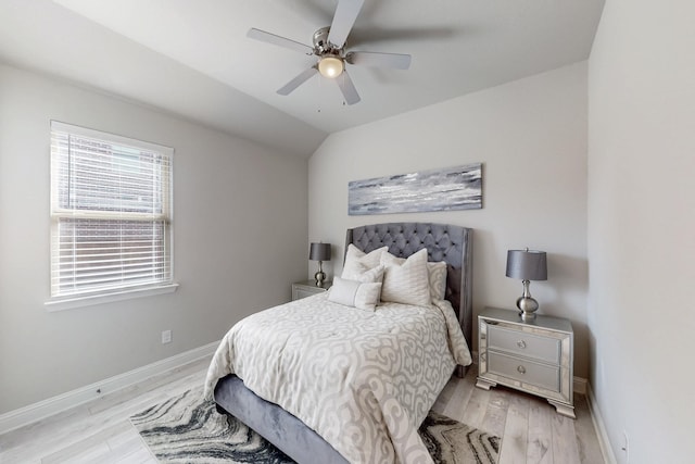 bedroom with light wood-style flooring, lofted ceiling, baseboards, and a ceiling fan