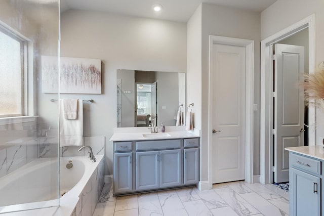 ensuite bathroom with a bath, ensuite bath, marble finish floor, and vanity