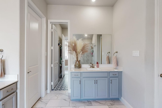 full bathroom featuring a shower stall, baseboards, marble finish floor, and vanity
