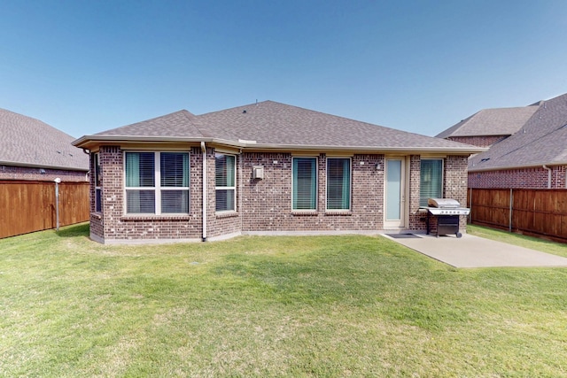 rear view of house featuring a fenced backyard, brick siding, a patio area, and a lawn