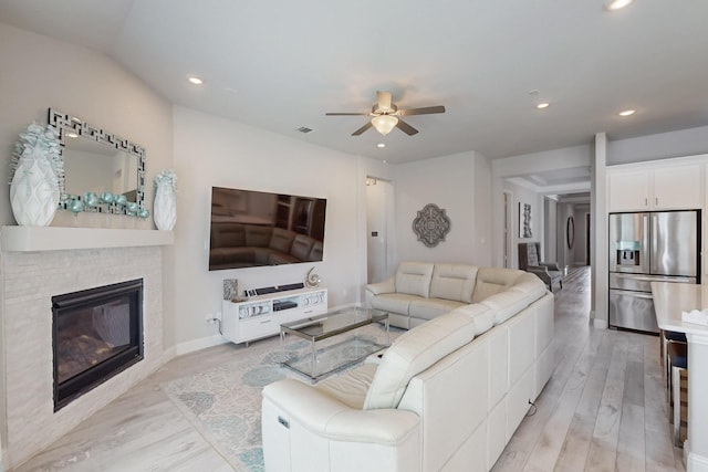living area featuring recessed lighting, light wood-type flooring, and a ceiling fan