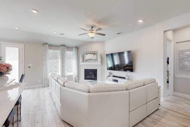 living area featuring baseboards, a ceiling fan, light wood-style floors, and visible vents