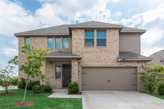 view of front of home with driveway, brick siding, an attached garage, a shingled roof, and a front yard