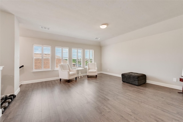 sitting room with dark wood finished floors, visible vents, and baseboards