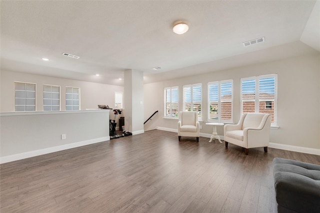 sitting room featuring visible vents, baseboards, dark wood-style flooring, and an upstairs landing