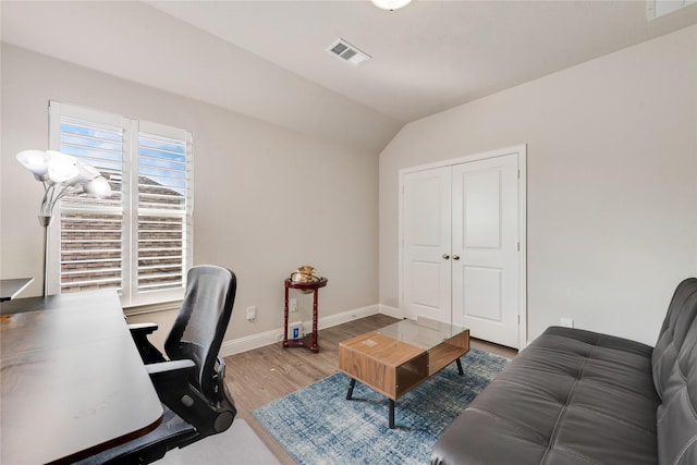 office area with vaulted ceiling, baseboards, wood finished floors, and visible vents