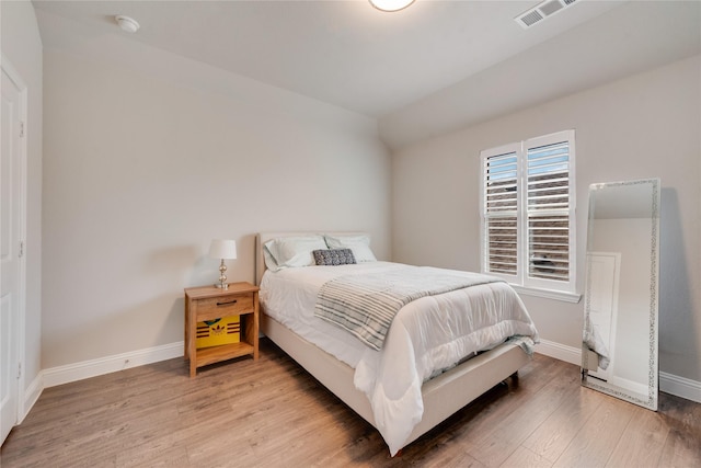 bedroom featuring baseboards, visible vents, and light wood-style flooring