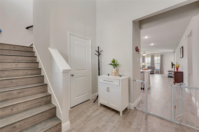 stairs featuring baseboards, wood finished floors, and recessed lighting