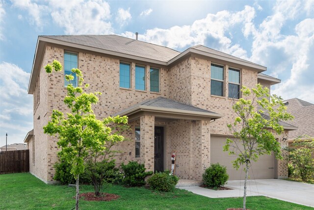 view of front of property with an attached garage, brick siding, fence, and driveway