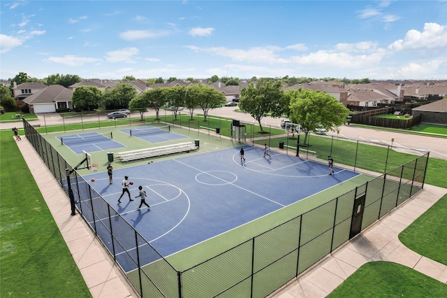 view of sport court featuring a yard, a residential view, community basketball court, and fence