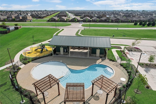community pool with a lawn and a residential view