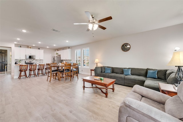 living room with ceiling fan, light wood finished floors, visible vents, and recessed lighting