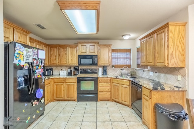 4910 Coyote Run, Abilene, TX 79602 - kitchen with black appliances, a sink, backsplash, light tile patterned floors, and light stone counters