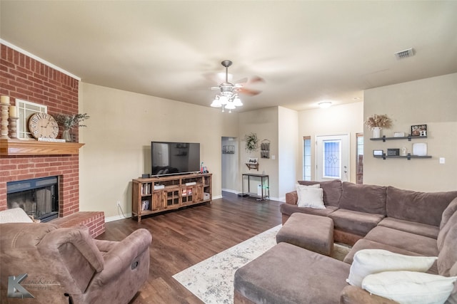 4910 Coyote Run, Abilene, TX 79602 - living room featuring dark wood-style floors, a ceiling fan, a brick fireplace, and baseboards