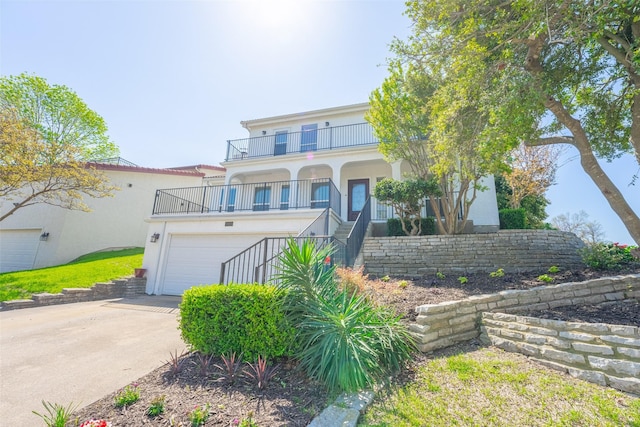 view of front of property featuring stairs, a balcony, concrete driveway, stucco siding, and a garage