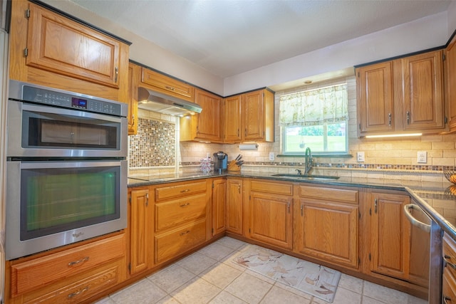 kitchen featuring a sink, extractor fan, appliances with stainless steel finishes, and tasteful backsplash