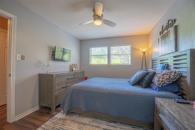 bedroom featuring baseboards, a ceiling fan, and wood finished floors