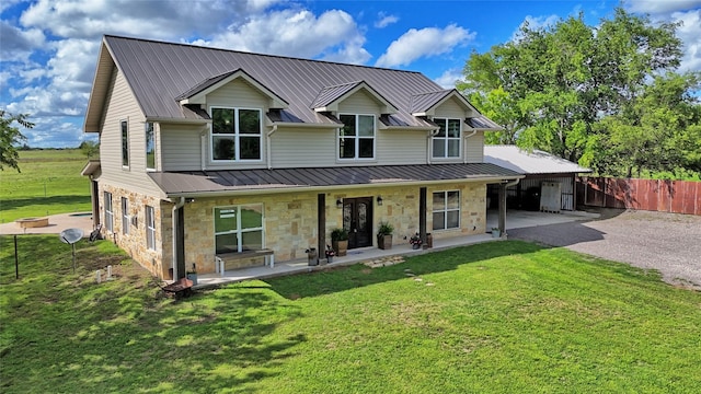 209 E Meadows St, Saint Jo, TX 76265 - back of house featuring stone siding, driveway, metal roof, and a carport