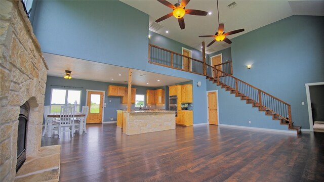 unfurnished living room featuring high vaulted ceiling, a ceiling fan, dark wood-style flooring, and visible vents