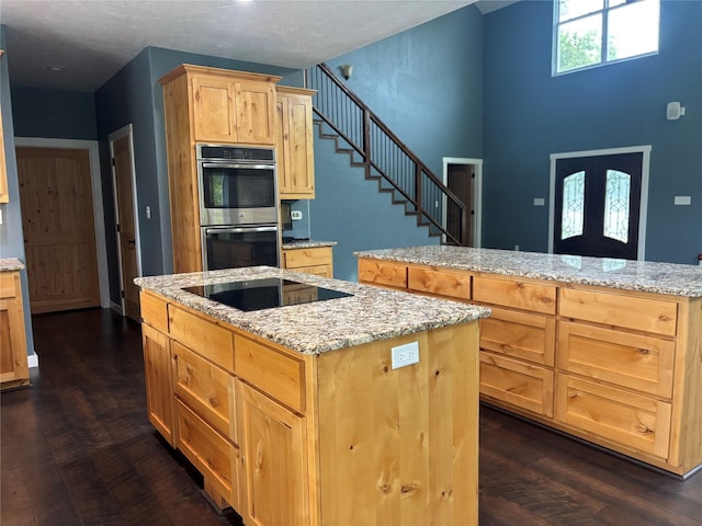 209 E Meadows St, Saint Jo, TX 76265 - kitchen featuring stainless steel double oven, black electric stovetop, light brown cabinetry, a center island, and light stone counters