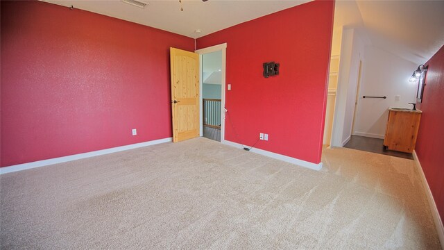 unfurnished bedroom featuring carpet floors, baseboards, and visible vents