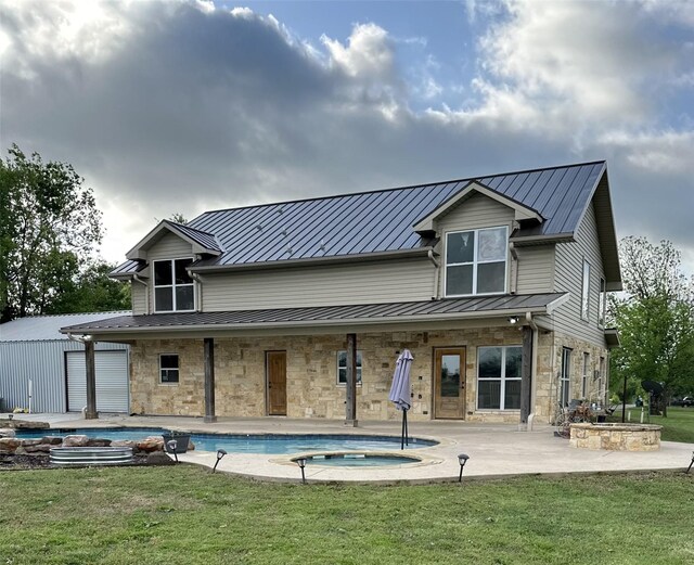 view of pool with fence, a patio, a lawn, and a pool with connected hot tub