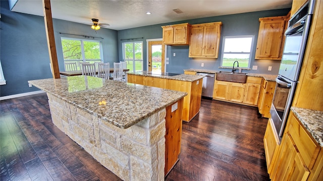 209 E Meadows St, Saint Jo, TX 76265 - kitchen featuring a center island, a sink, dishwasher, a ceiling fan, and dark wood finished floors