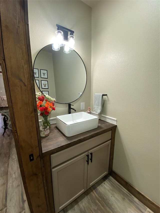 1609 Beech St, Cisco, TX 76437 - bathroom with wood finished floors, vanity, and baseboards