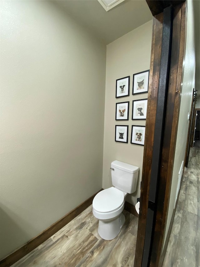1609 Beech St, Cisco, TX 76437 - half bathroom with wood finished floors, toilet, and baseboards