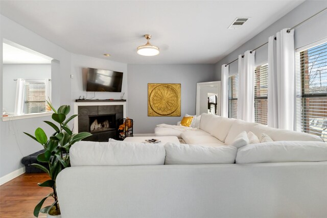 2409 Eisenhower Dr, Mckinney, TX 75071 - living area with baseboards, a fireplace, wood finished floors, and visible vents