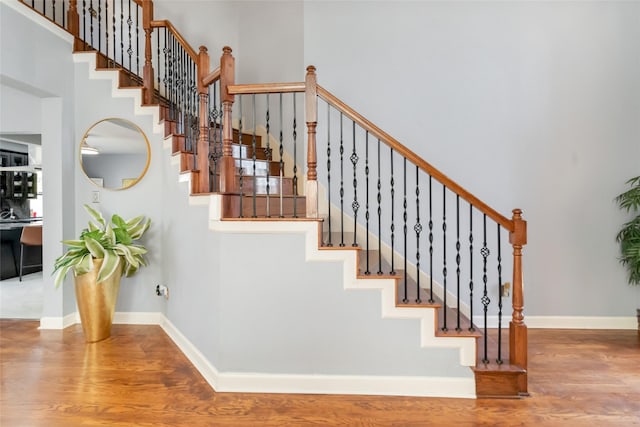 2409 Eisenhower Dr, Mckinney, TX 75071 - staircase with baseboards, a towering ceiling, and wood finished floors