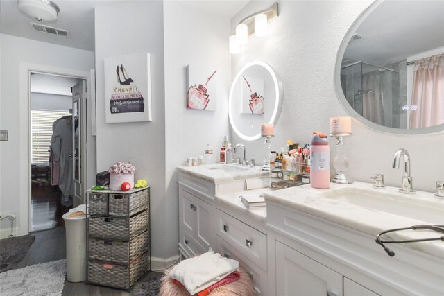 2409 Eisenhower Dr, Mckinney, TX 75071 - bathroom with double vanity, visible vents, a shower stall, and a sink