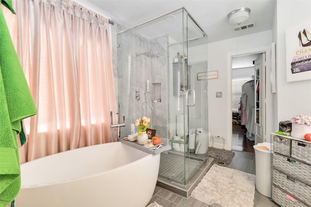 2409 Eisenhower Dr, Mckinney, TX 75071 - bathroom featuring visible vents, a stall shower, a freestanding bath, and wood finished floors