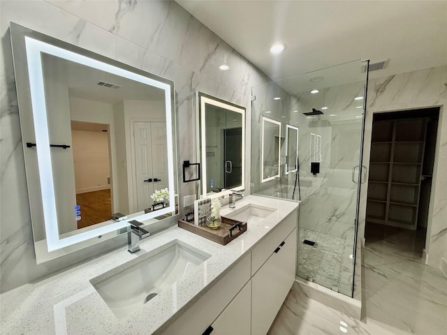 bathroom featuring a sink, a marble finish shower, marble finish floor, and visible vents