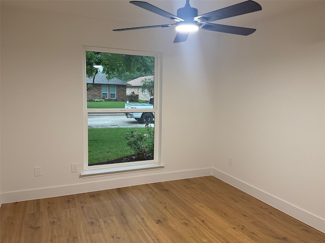 spare room featuring baseboards, a ceiling fan, and wood finished floors