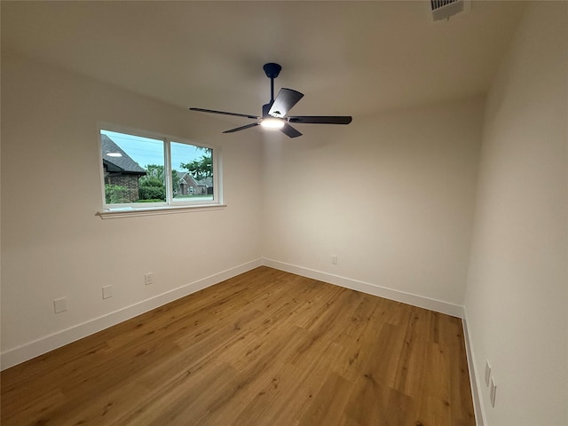 empty room with baseboards, ceiling fan, and light wood-type flooring