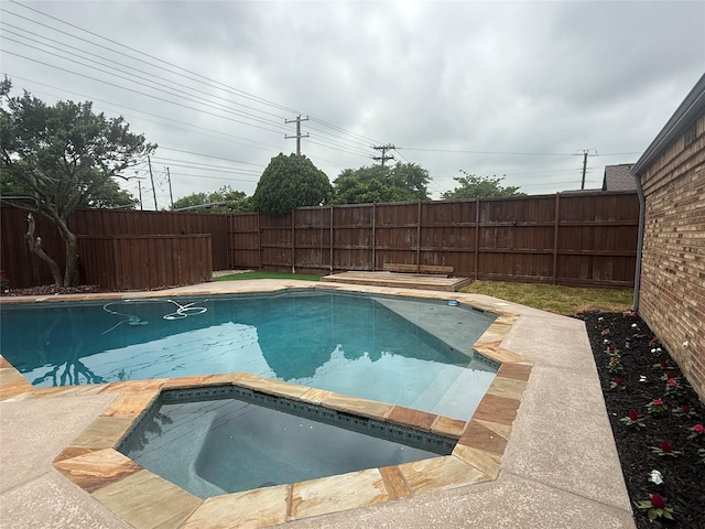 view of swimming pool with a fenced in pool, a fenced backyard, and an in ground hot tub
