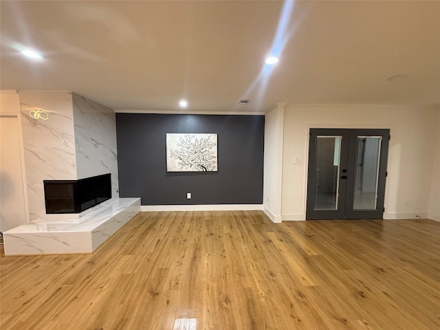 unfurnished living room featuring baseboards, french doors, recessed lighting, and wood finished floors