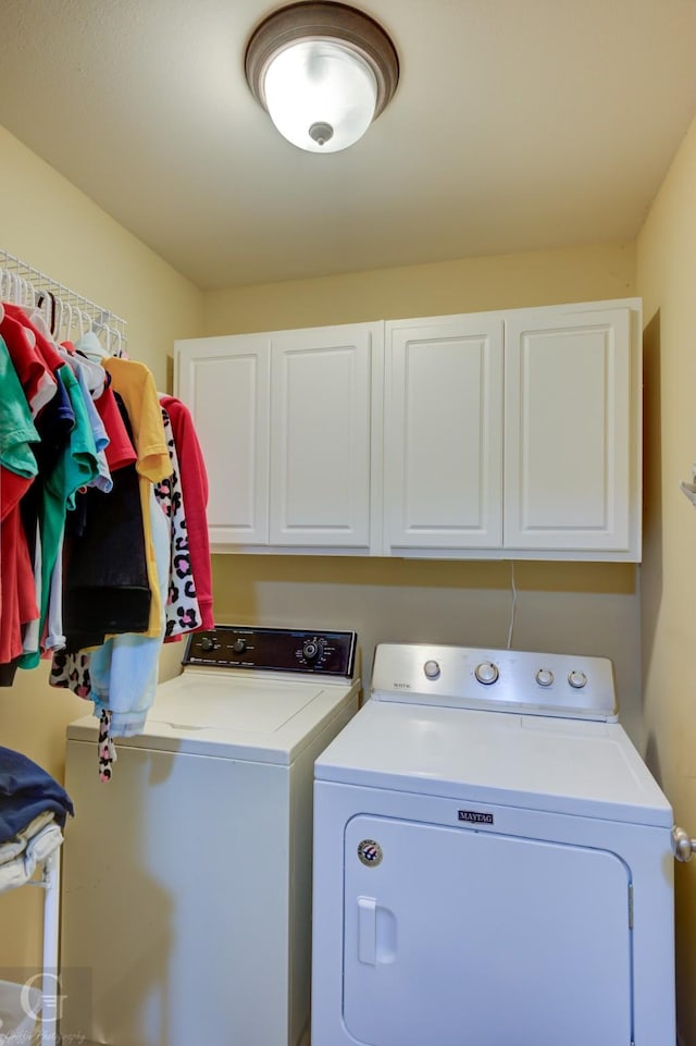 washroom featuring washing machine and clothes dryer and cabinet space