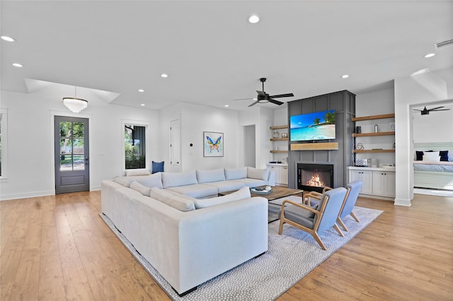 8919 Southern Shore Ct, Kemp, TX 75143 - living room with light wood-style flooring, a large fireplace, recessed lighting, and ceiling fan