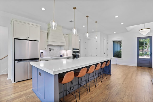 8919 Southern Shore Ct, Kemp, TX 75143 - kitchen featuring light wood-style flooring, custom exhaust hood, recessed lighting, and appliances with stainless steel finishes